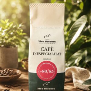 Presentación del paquete de café de especialidad ecológico de Cafès Illes Balears sobre mesa de madera rodeado de granos tostados y naturaleza.